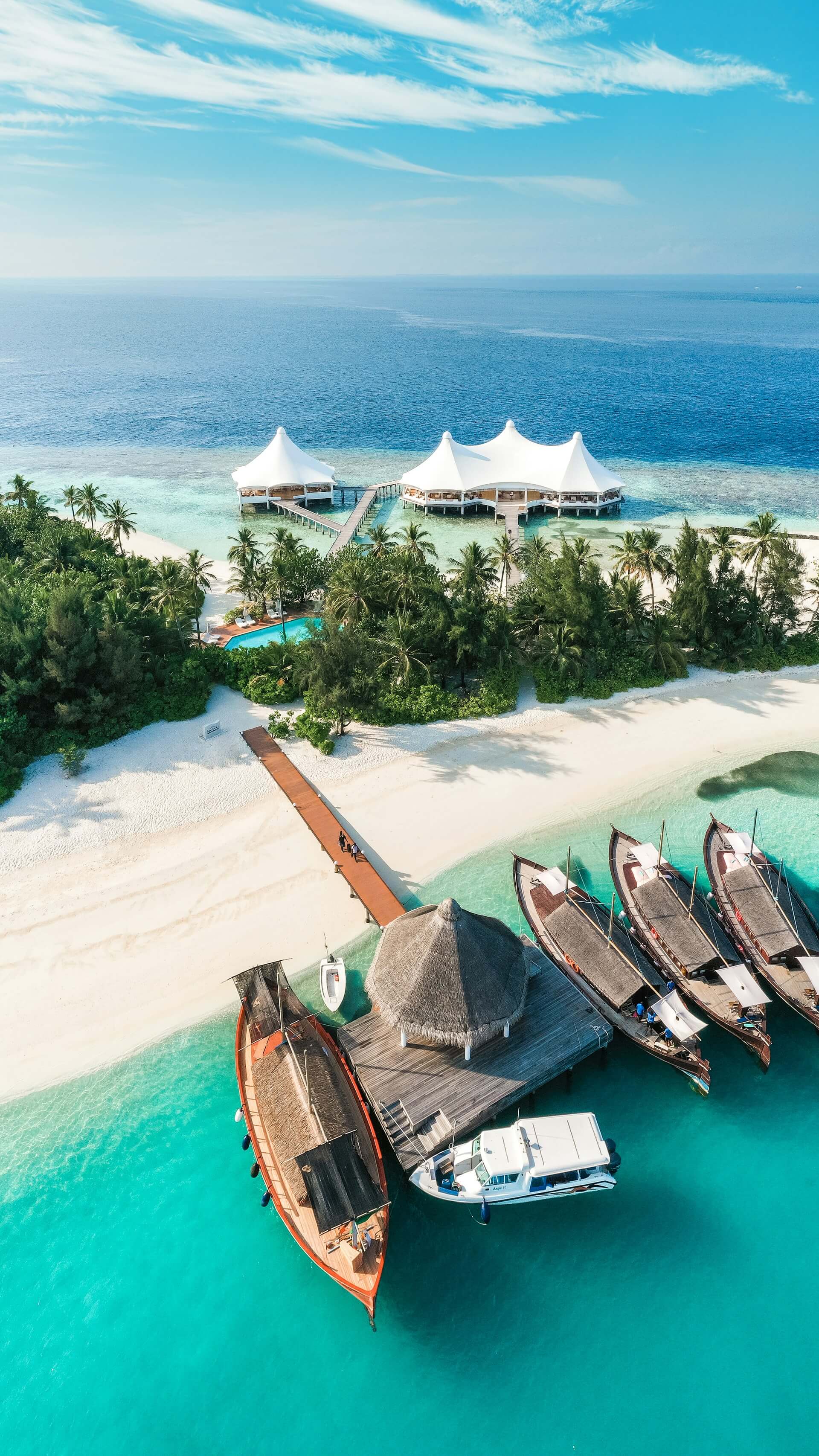 Aerial view of an island resort and overwater villas in the Maldives