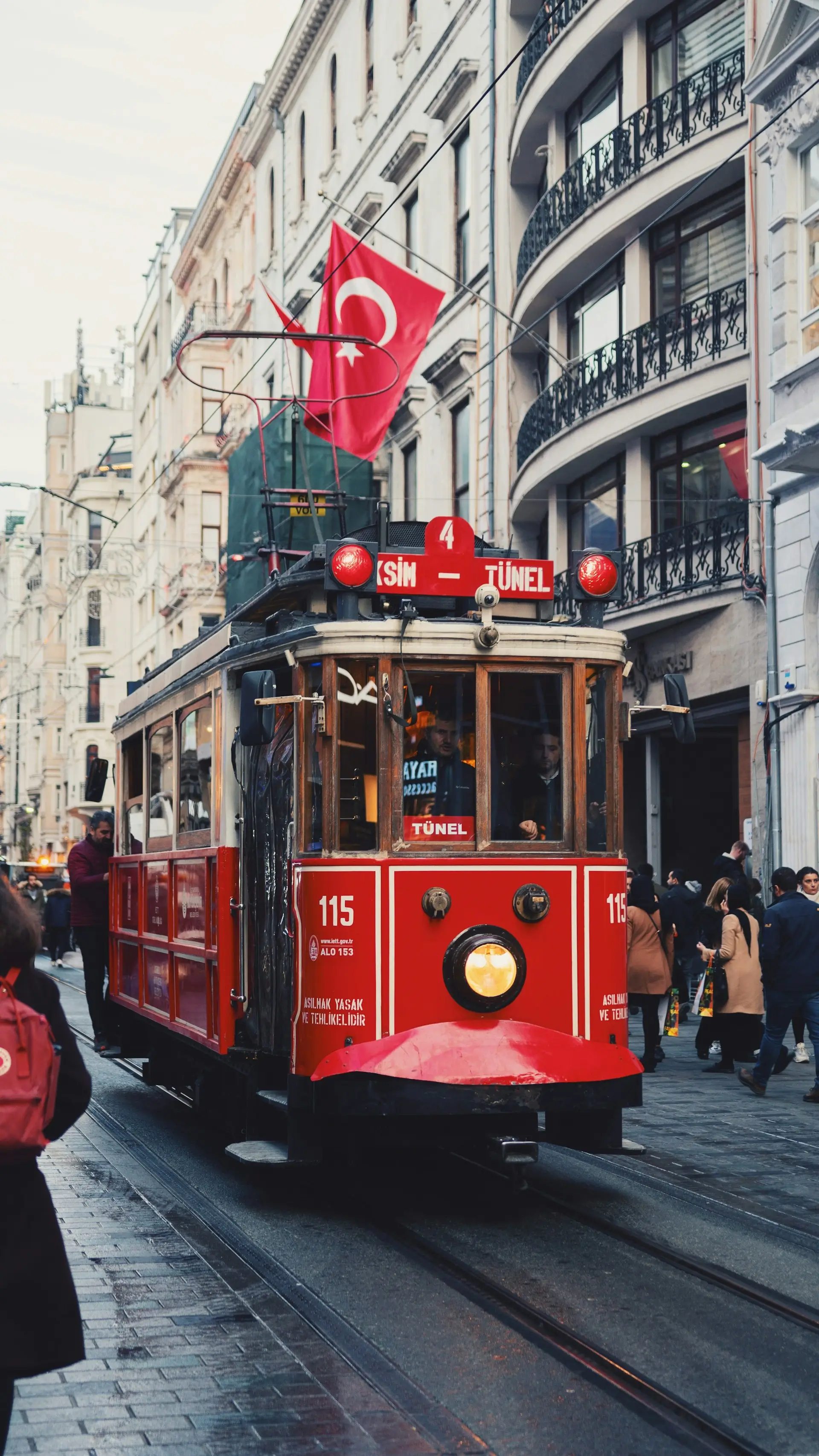 A red heritage tram on a lively Istanbul street, Turkey
