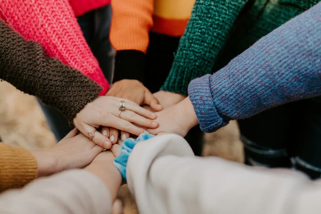 A group joining hands in a gesture of teamwork